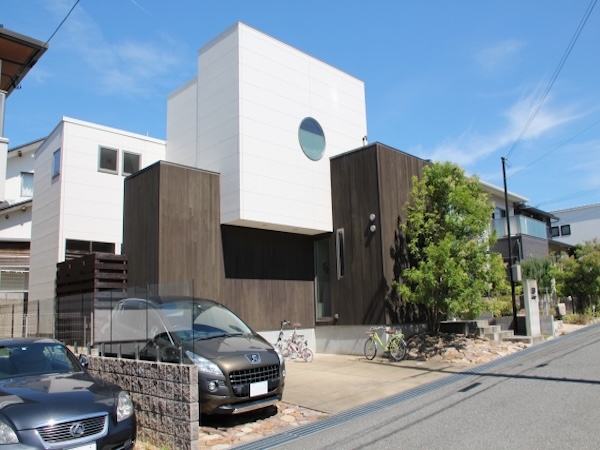 植栽や石を使ったアプローチが外観と調和する住宅。建物と外構を統一したデザインで、まとまりのある外観に仕上がっている様子