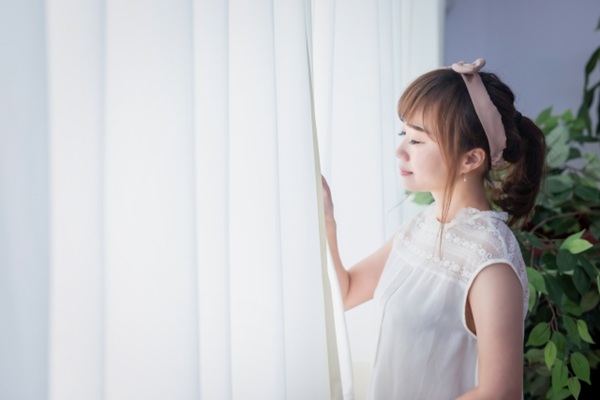 注文住宅の窓計画|位置で変わる暮らしやすさと光・風の取り入れ方-自然光を浴びる女性
